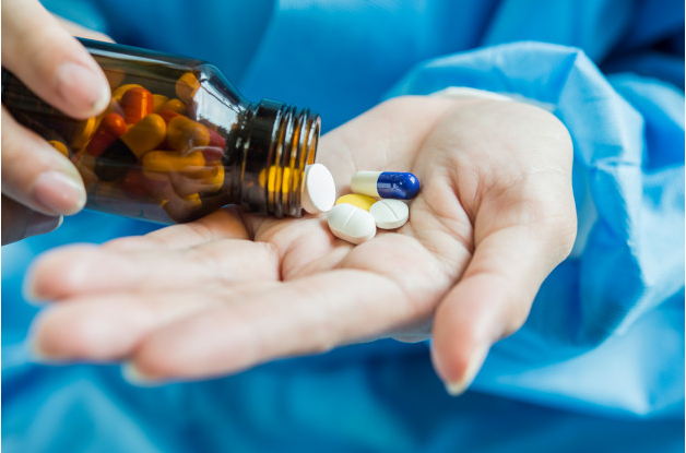 Medication - physician holding medicine in hand